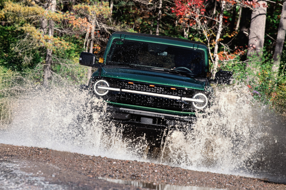 Green Jeep Splashing Through Shallow Water