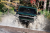 Green Jeep Splashing Through Shallow Water